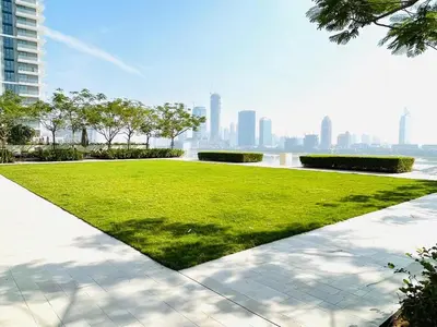a grassy area with a city in the background at Stunning and Cozy Home with Marina and Sea View in Dubai