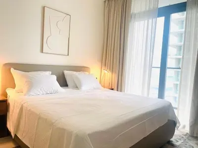 a bedroom with a large white bed with a window at Stunning and Cozy Home with Marina and Sea View in Dubai