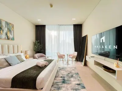 a bedroom with a large bed and a table with chairs at Elevated Studio Living at Binghatti Phoenix in Dubai