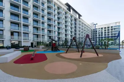 an empty playground in front of a building at Elevated Studio Living at Binghatti Phoenix in Dubai
