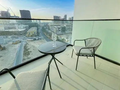 a glass table and two chairs on a balcony at Elevated Studio Living at Binghatti Phoenix in Dubai