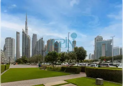 a city skyline with cars parked in a park at Aspin Brand New Premium Studio with Pool View - Burj Views in Dubai