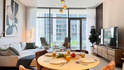 a living room with a table and a couch at 2 Bed with Direct Park Access - Calm and Peaceful in Dubai