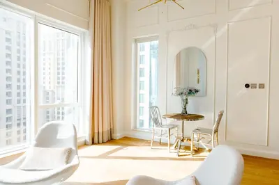 a living room with a table and chairs and large windows at Dubai Marina Penthouse Suite - Prime Location in Dubai