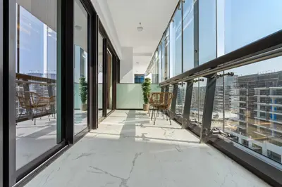 a balcony with windows and chairs in a building at Modern 1BR Apartment w Balcony in Meydan in Dubai