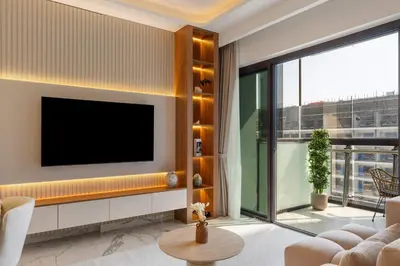 a living room with a tv on a wall at Modern 1BR Apartment w Balcony in Meydan in Dubai