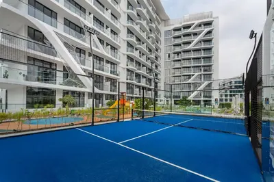 a tennis court in front of a apartment building at Oxford Gardens Premium Studio with Cinema & Game Room in Dubai