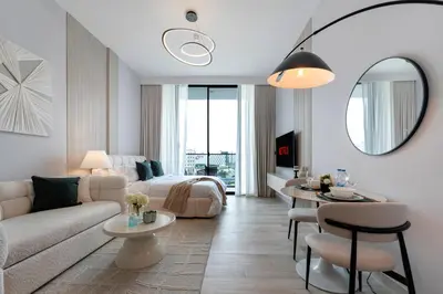 a living room with a couch and a table at Oxford Gardens Premium Studio with Cinema & Game Room in Dubai
