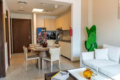 a living room with a couch and a table with chairs at Werova - Urban Living 1BR Apartment in JVC in Dubai