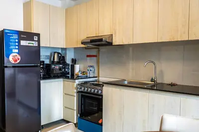 a kitchen with a stove and a sink and a refrigerator at Werova - Urban Living 1BR Apartment in JVC in Dubai
