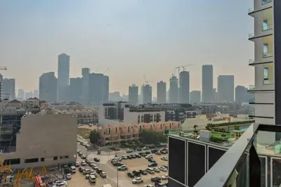 a city skyline with cars parked in a parking lot at Werova - Urban Living 1BR Apartment in JVC in Dubai