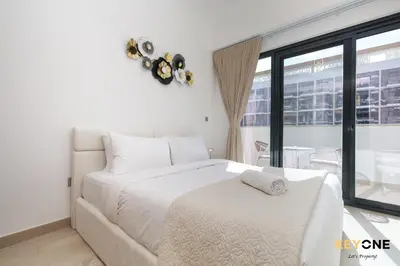 a white bedroom with a white bed and a window at Stylish Riviera Studio Near Downtown in Dubai