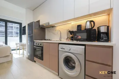 a kitchen with a washer and dryer in it at Stylish Riviera Studio Near Downtown in Dubai