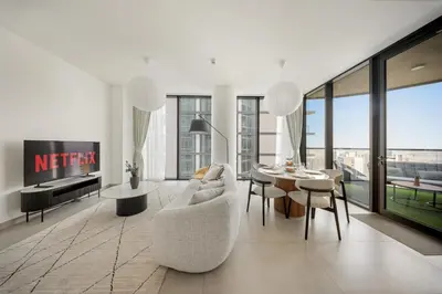 a living room with a couch and a table at VayK - Stylish 2BR & Maids Apartment in Sobha Hartland in Dubai
