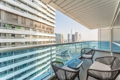 a balcony with chairs and a table on a building at Minutes from Marina Promenade, Surrounded by Shops, and a Short Drive to Ain Dubai, Opal Tower, Dubai Marina by Deluxe Holiday Homes in Dubai
