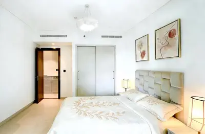 a bedroom with a large bed with a white bedspread at Sohba Creek Vistas Luxury 2 Bedroom with Free Parking in Downtown Dubai Near Burj Khalifa in Dubai