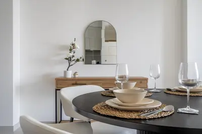 a dining room table with two chairs and a mirror at Iconic Burj Views l Elegant 2BR at Burj Royale in Dubai