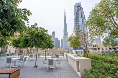 a patio with tables and chairs and a view of the city at Iconic Burj Views l Elegant 2BR at Burj Royale in Dubai
