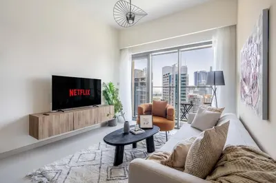 a living room with a couch and a tv at Iconic Burj Views l Elegant 2BR at Burj Royale in Dubai