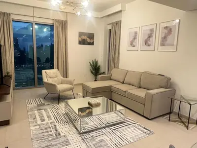 a living room with a couch and a table at BAZ HOMES - Burj Khalifa View 2BR Connected to Dubai Mall in Dubai