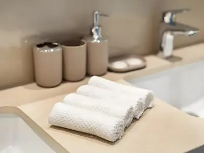 a bathroom counter with white towels on a sink at BAZ HOMES - Burj Khalifa View 2BR Connected to Dubai Mall in Dubai