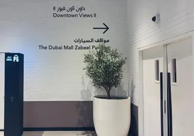 a plant in a large pot next to a door at BAZ HOMES - Burj Khalifa View 2BR Connected to Dubai Mall in Dubai