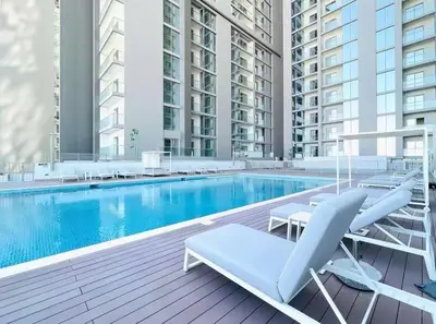 a swimming pool with two lounge chairs and a table at Sohba Creek Vistas Luxury 2 Bedroom with Free Parking in Downtown Dubai Near Burj Khalifa in Dubai