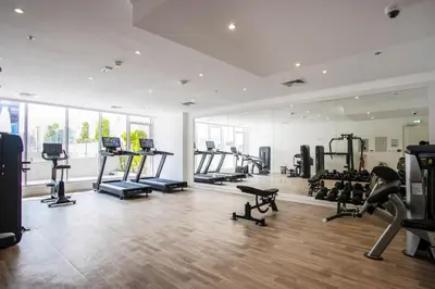 a gym with treadmills and machines in a room at Relaxing 1BR Peaceful Family Living in JVC in Dubai