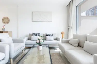 a living room with white couches and a glass table at Relaxing 1BR Peaceful Family Living in JVC in Dubai