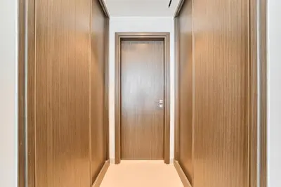 a corridor with wooden doors in a building at 2BR Beachfront Apartment at Palace Beach Residence in Dubai