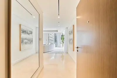 a hallway with a pivot door and a hallway with white walls at 2BR Beachfront Apartment at Palace Beach Residence in Dubai