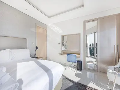 a bedroom with a bed and a desk and a window at Spacious 3BR in Paramount Tower Luxury Living in Dubai