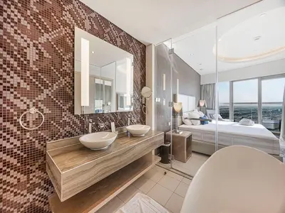 a bathroom with two sinks and a bed and a mirror at Spacious 3BR in Paramount Tower Luxury Living in Dubai
