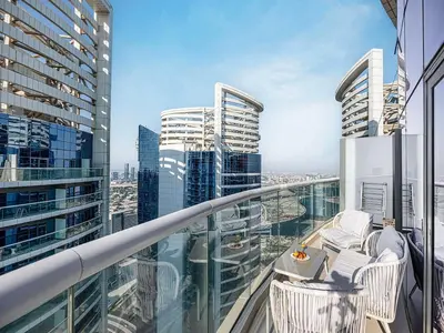 a balcony with chairs and a view of a city at Spacious 3BR in Paramount Tower Luxury Living in Dubai