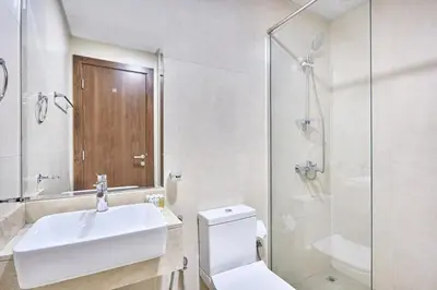 a bathroom with a sink and a toilet and a shower at Urban and Central - 1BR at Binghatti Gateway in Dubai