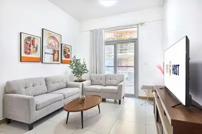 a living room with a couch and a tv at Urban and Central - 1BR at Binghatti Gateway in Dubai