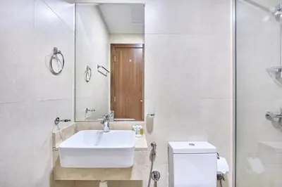 a bathroom with a sink and a toilet and a mirror at Urban and Central - 1BR at Binghatti Gateway in Dubai