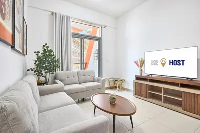 a living room with a couch and a tv at Urban and Central - 1BR at Binghatti Gateway in Dubai