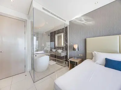 a bedroom with a bed and a tub and a bathroom at Spacious 3BR in Paramount Tower Luxury Living in Dubai