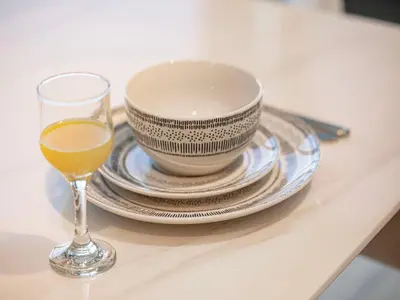 a glass of orange juice next to a bowl and plates at Spacious 3BR in Paramount Tower Luxury Living in Dubai