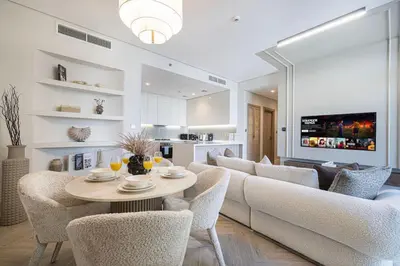 a living room with a table and chairs at Brand New Exclusive 2BR, Burj and Canal View in Dubai