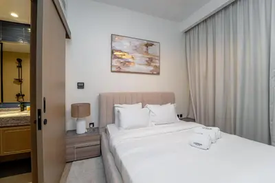 a bedroom with a large bed with white pillows at Stylish 4 Bedroom Home with Garden in DAMAC Lagoons in Dubai Marina