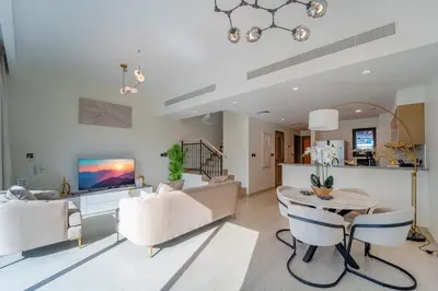 a living room with a couch and a table at Stylish 4 Bedroom Home with Garden in DAMAC Lagoons in Dubai Marina