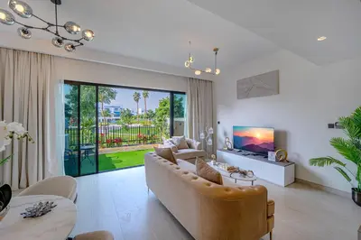 a living room with a couch and a tv at Stylish 4 Bedroom Home with Garden in DAMAC Lagoons in Dubai Marina