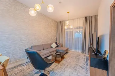 a living room with a couch and a television at Premium 1BR King Bed Dubai Healthcare City in Dubai