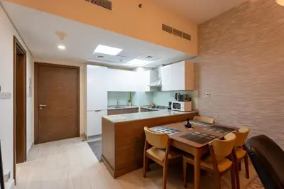 a kitchen with a table and chairs in a room at Premium 1BR King Bed Dubai Healthcare City in Dubai