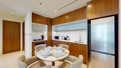 a kitchen with a table and chairs and a refrigerator at Vacationer l Classy 1 Bedroom l Yacht Views l Private Beach in Dubai