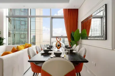 a dining room with a table and chairs and a large window at 5-Star Living | Luxury 2B & Amenities in Dubai