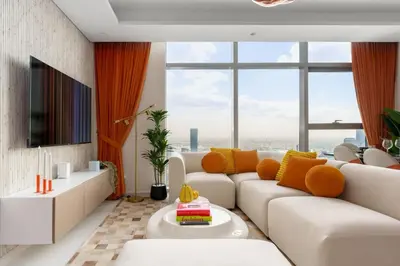 a living room with a white couch and orange curtains at 5-Star Living | Luxury 2B & Amenities in Dubai