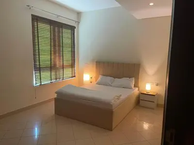 a bedroom with a bed and a window and two lamps at Stunning rooms in the Canal in Dubai